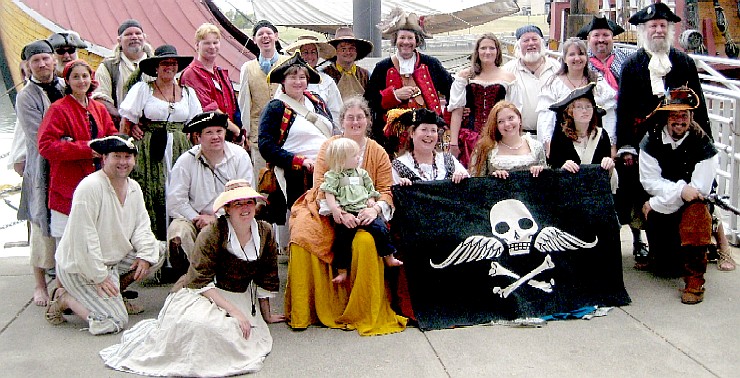 The pirates in front of the Santa Maria with the Mercury flag