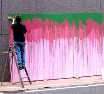 Artist spray painting his canvases