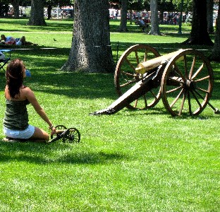 A girl pointing one of the mini-cannons in front of a larger cannon